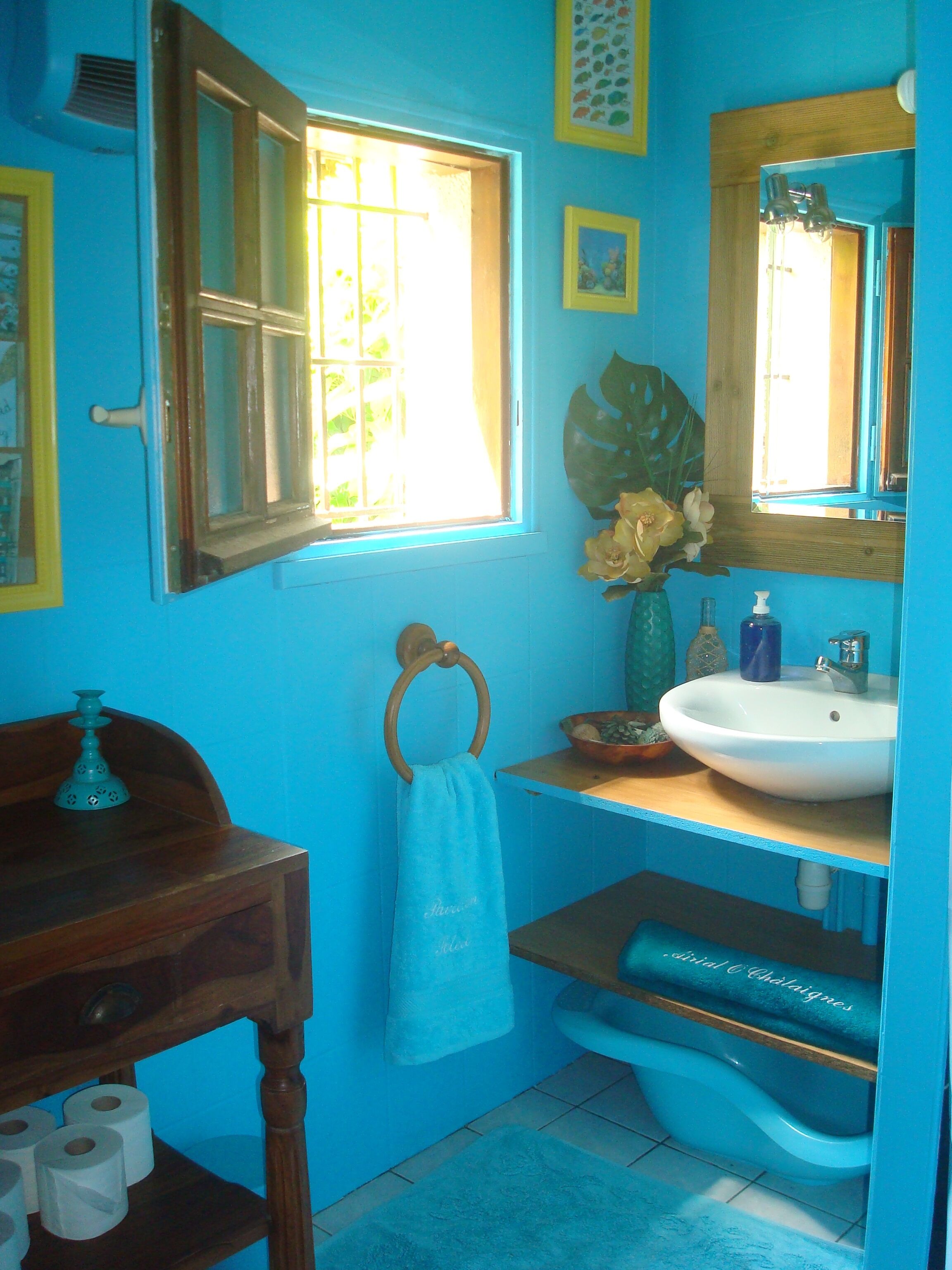 Un bagno con lavandino, WC e finestra.