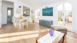 Un vaste espace de vie comprenant une table à manger en bois, un canapé et une grande fenêtre.