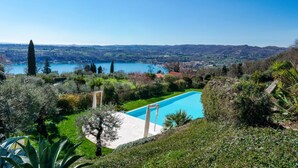 A pool with a clear view of a lake and distant hills. - WOW what a view! Charming apartment with terrace, pool and fitness center (Salo')