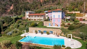 A hillside villa with a swimming pool, terraced gardens, and a stone wall. - WOW what a view! Charming apartment with terrace, pool and fitness center (Salo')
