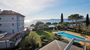 A view of a pool area with a clear sky and a distant body of water.