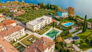 A residential area with a large building, a swimming pool, and a view of a lake.