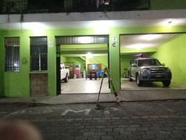Un estacionamiento con paredes verdes y entrada pavimentada.