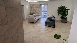 A modern living room with a sofa, a coffee table, and a potted plant.