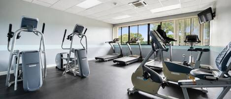 A fitness center with treadmills, elliptical machines, and a stair climber.