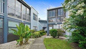 A modern two-story residential building with a covered walkway and a small garden area. - 3919 Orlando Vacational Apartment (Orlando)