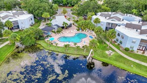 A residential area with a swimming pool surrounded by palm trees and a fountain. - 3919 Orlando Vacational Apartment (Orlando)