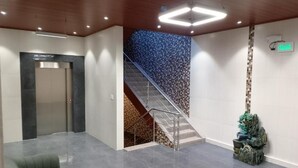 A lobby with a staircase, a reception desk, and a decorative rock feature. - Hospedaje Ciste (Panama City)