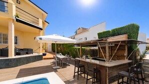 A poolside area with a bar, outdoor seating, and a view of the surrounding buildings.
