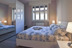 A bedroom with a bed, two bedside lamps, a window, and a radiator. - Apartments Florence- Barbadori Apartment (Firenze)