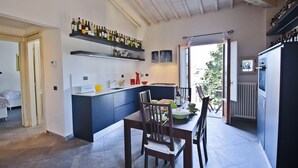 Eine moderne Küche mit einer zentralen Kochinsel, eingebauten Regalen mit Weinflaschen und einem Essbereich mit Stühlen und einem Tisch.