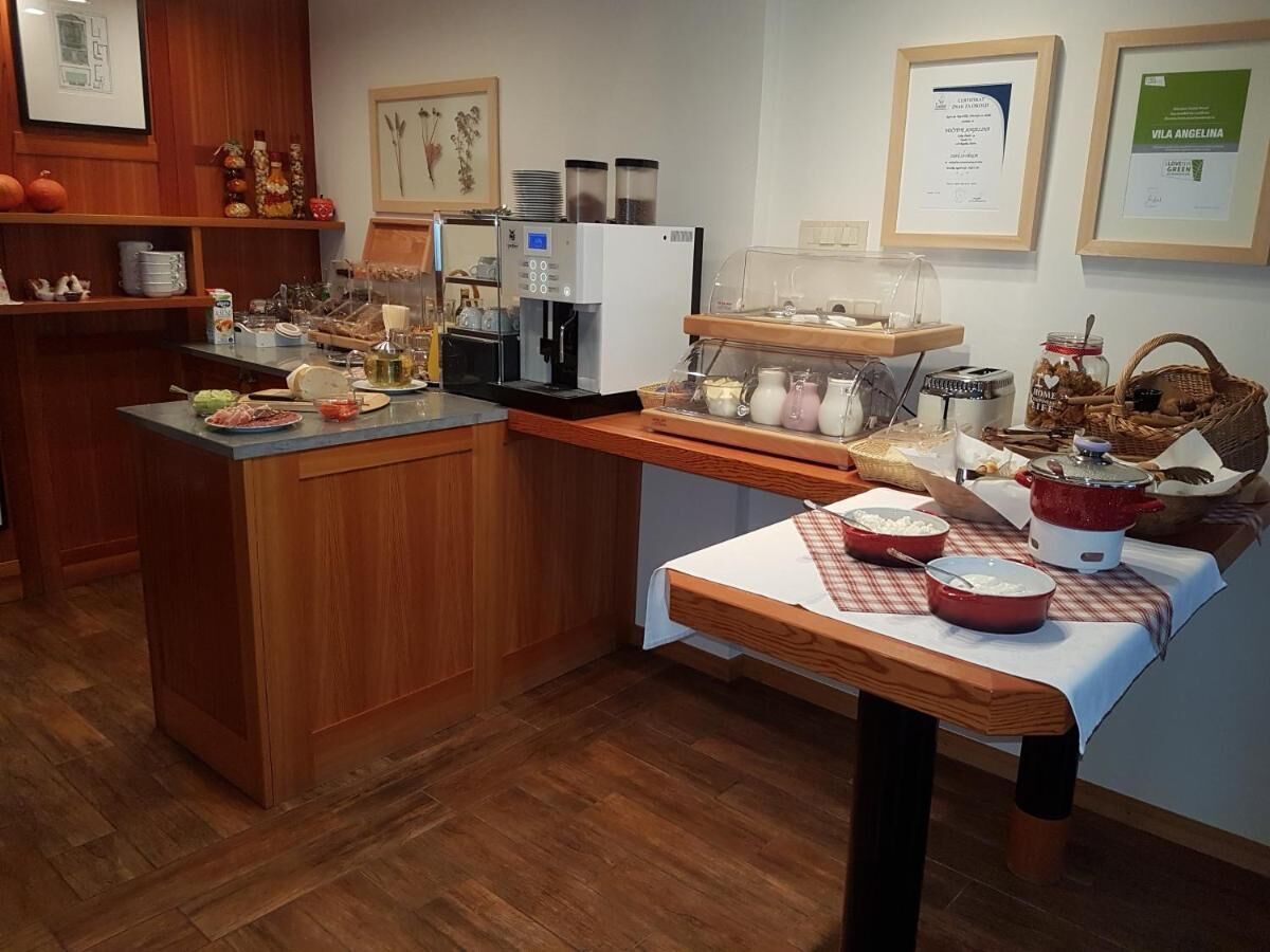 A kitchen with wooden cabinets, a coffee machine, and a table with food items.
