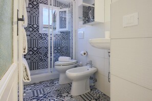 Regadera, secadora de cabello, bidet, papel de baño 