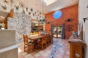 A dining area with a stone wall, wooden table, and chairs.