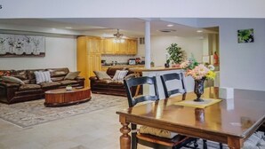 Un salón amplio con una gran mesa de madera para comer, un sofá y una mesa de centro.