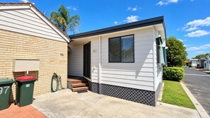 A mobile home with a porch, a mailbox, and a trash bin. - Budgie Smuggler - Cabin 96 GBHP (West Busselton)