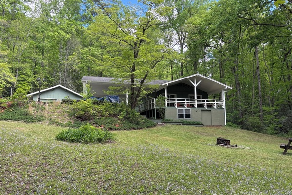The covered deck looks out over the property. Fire ring in the foreground.