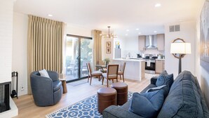 A modern living room with a sofa, armchair, ottoman, and a dining area with chairs and a table. - Renovated! Wine Country Gem, 1 bed/1 bath + Sleeper Sofa, Sleeps 4! (Napa)