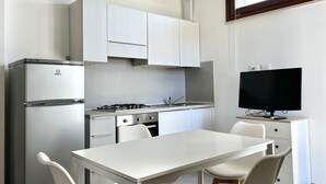 Cocina moderna con refrigerador, estufa y comedor.