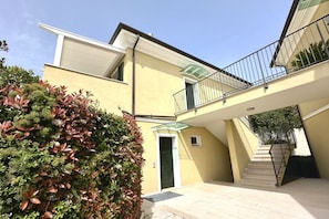 Ein zweistöckiges Gebäude mit Balkon, Treppe und einer Tür.