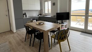 A modern kitchen with a dining area, a TV, and a balcony with a view. - S334 - Sirolo, wonderful panoramic three-room apartment (Sirolo)
