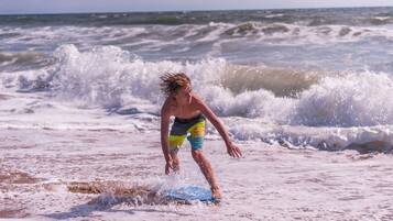Una persona che fa surf su una spiaggia con le onde.