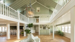 A spacious interior with a high ceiling, a dining area, kitchen, and a seating area with a view. - Oceanside King Suite | Near Pool + Private Beach (Duck)