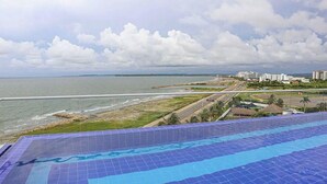 Une vue prise depuis un point de vue surélevé, donnant sur une plage avec une piscine au premier plan.