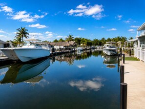 A marina with boats docked, a clear sky, and tropical vegetation. - Canal Waterfront ocean side w boat ramp & Hot Tub. Sleep 8 in Key Largo (Key Largo)