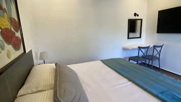 A bedroom with a bed, a desk, and a chair.