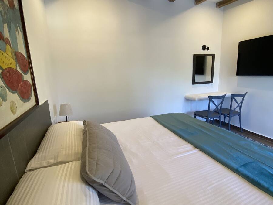 A bedroom with a bed, a desk, and a chair.