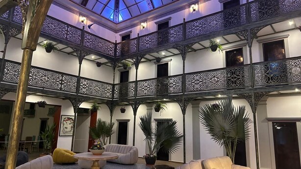 A spacious atrium with a high ceiling, ornate iron railings, and multiple seating areas. - Hotel Tierra Marina Centro Histórico (Mazatlán)