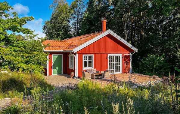 A red wooden house with a green door, white windows, and a chimney. - 3 bedroom beautiful home in Sölvesborg (Sölvesborg)