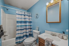 A bathroom with a shower, toilet, sink, and mirror. - Namba Cabin - Our Cabin (Great Cacapon)