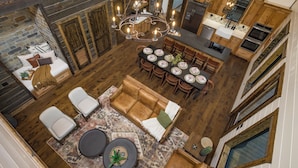 Uma sala ampla com lareira, mesa de jantar posta para seis e um ambiente acolhedor para relaxar.