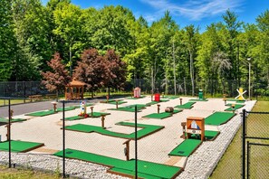 A miniature golf course with multiple holes, a gazebo, and a fence surrounding the area. - Sleep in a Treehouse!! (Lake Ariel)
