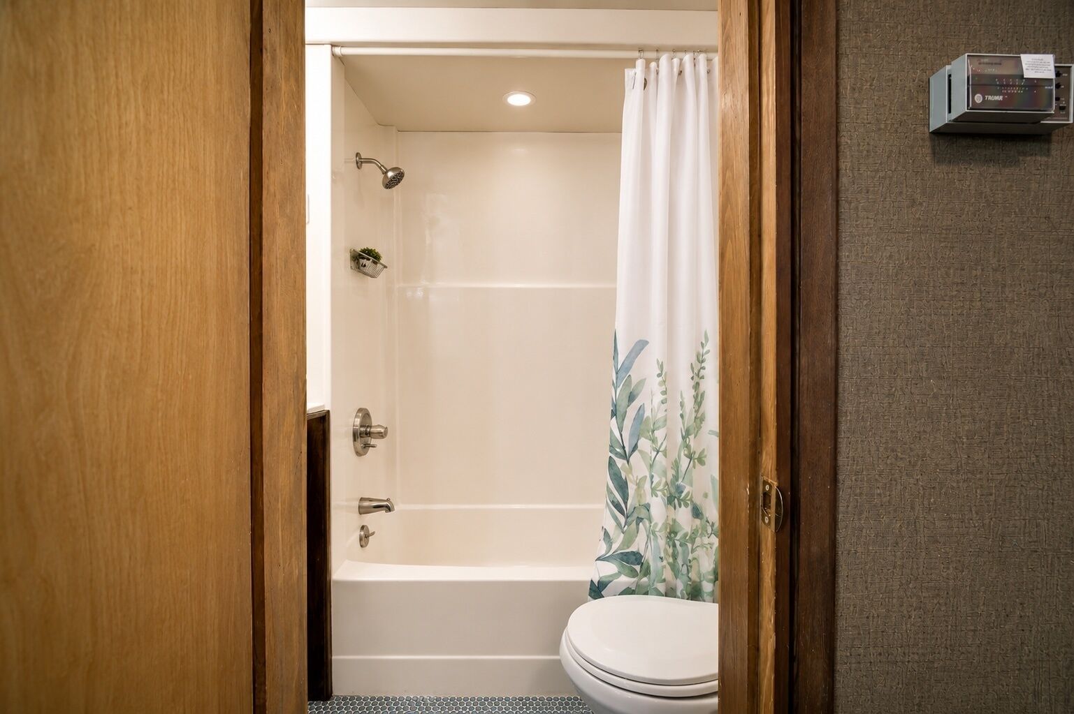 Une salle de bain avec une baignoire, des toilettes et un rideau de douche.