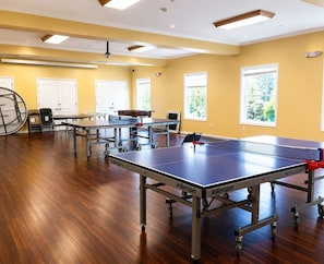 A room with multiple ping pong tables, chairs, and a large exercise ball. - Sleep in a Treehouse!! (Lake Ariel)
