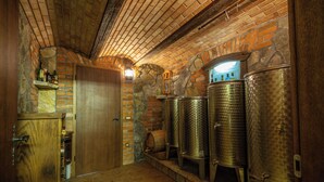 Une pièce avec un mur en briques, une porte en bois et des barils en métal.