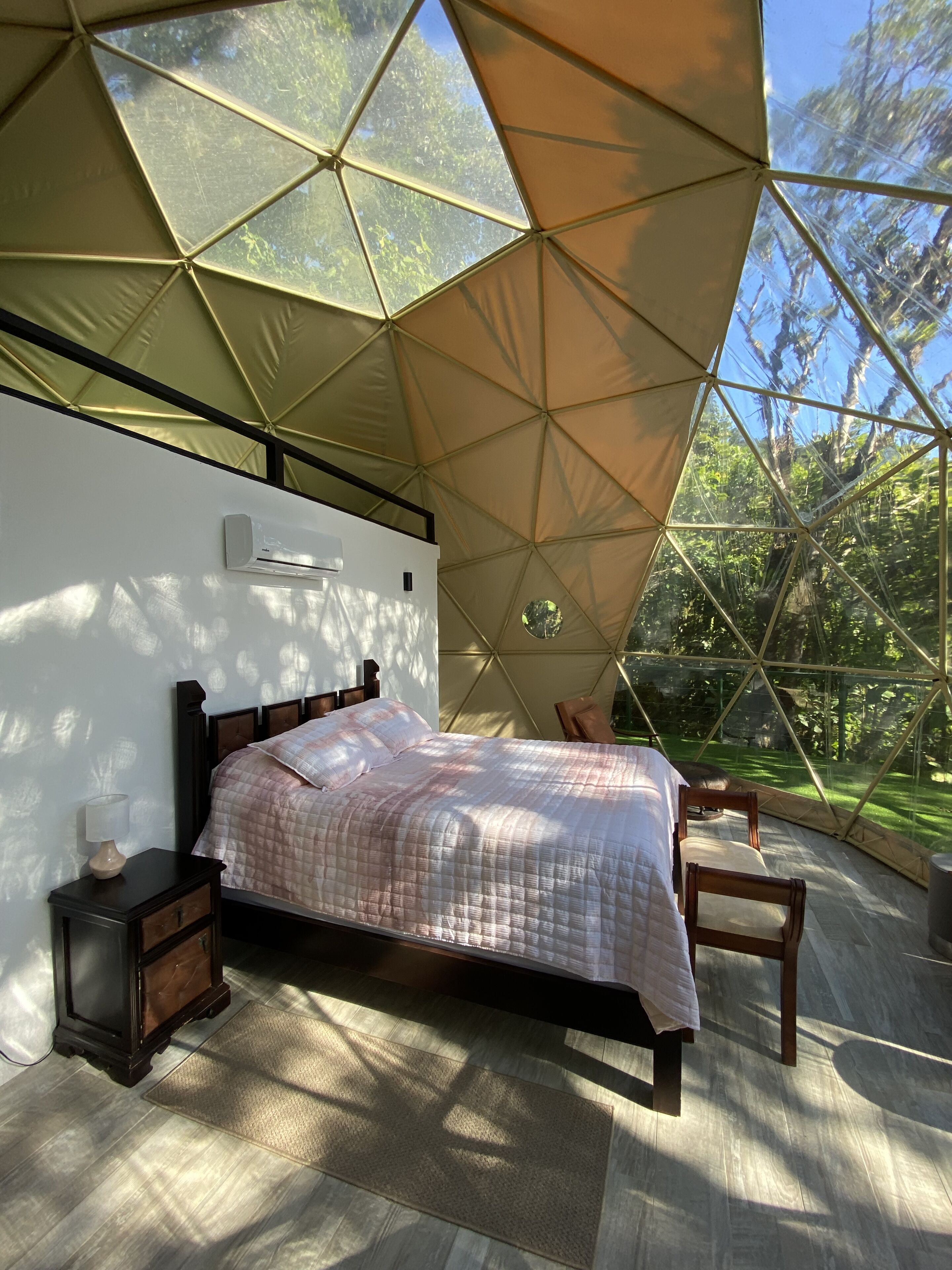 A bedroom with a bed, bedside table, lamp, and chair.