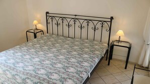 Una camera da letto con un letto, due comodini e una finestra con tende.