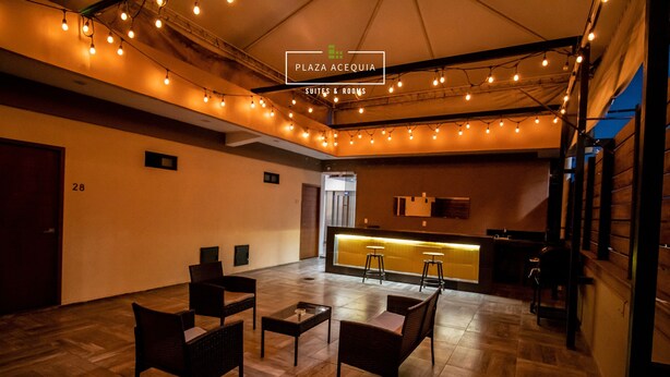 Un'ampia zona relax con pavimento in legno, diverse poltrone e tavolini. Si intravede una reception sullo sfondo.