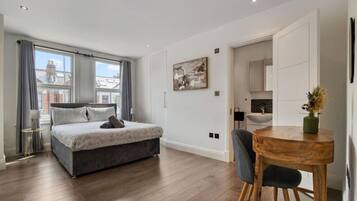 2 habitaciones, escritorio y tabla de planchar con plancha