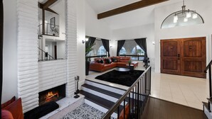 A spacious living area with a fireplace, a sectional sofa, and a staircase leading to an upper level. - Beautiful Fallbrook Estate Ideal for Weddings and Events (Fallbrook)