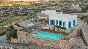 A modern villa with a swimming pool, stone walls, and a scenic hillside view. - Private 1-Bedroom Villa Suite in Mandrakia with Swimming Pool (Mandrakia)