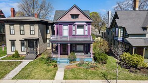 A two-story house with a balcony, a front porch, and a well-maintained lawn.