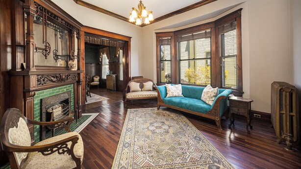 A spacious living room with a fireplace, a sofa, and a chandelier.