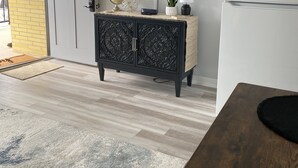 A modern kitchen with a black cabinet, a flat-screen TV mounted above it, and a white refrigerator. - Poolside Condo - Just 2 blocks from the Beach, Boardwalk and Seaport Pier!  (North Wildwood)