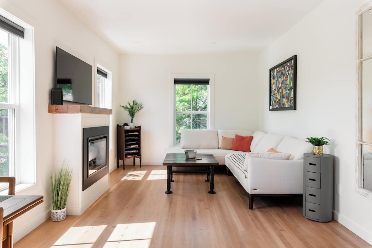 A modern living room with a fireplace, a sofa, a coffee table, and a bookshelf.