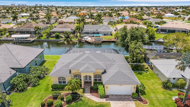 A residential area with houses, a swimming pool, and a dock. - Gulf Access, Kayaks, Heated Pool - Villa Happy Hour - Roelens Vacations (Cape Coral)